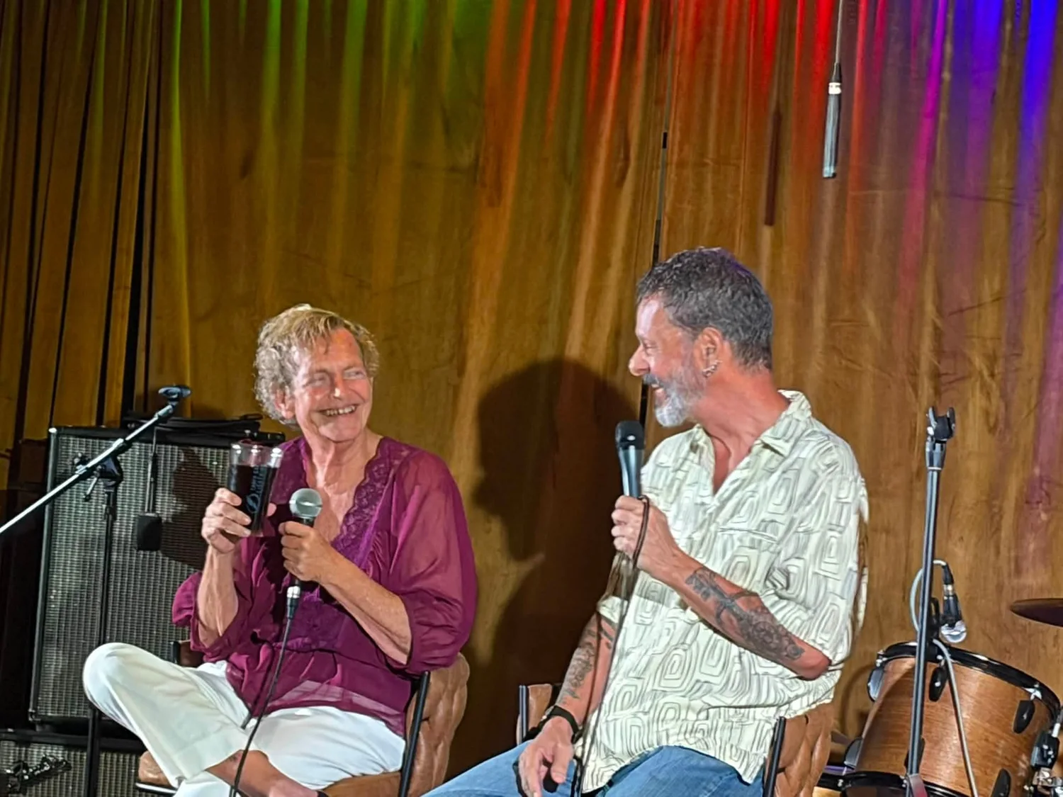 Flip and Rene seated together on stage in conversation with microphones
